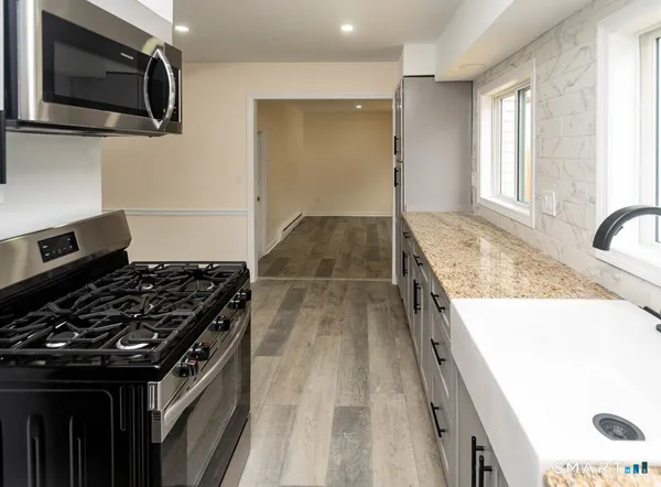 a kitchen with granite countertop a stove and a microwave