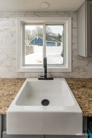a bathroom with a granite countertop sink and window