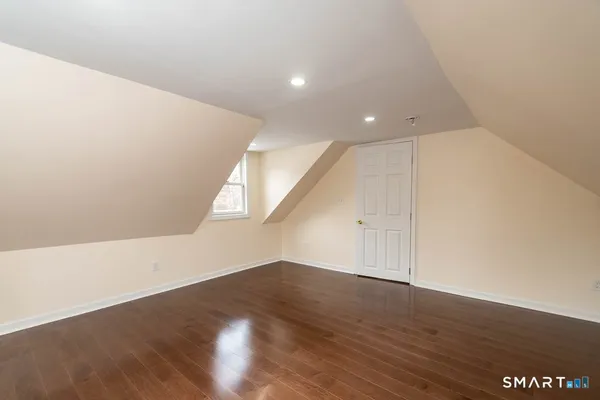 a view of an empty room with wooden floor