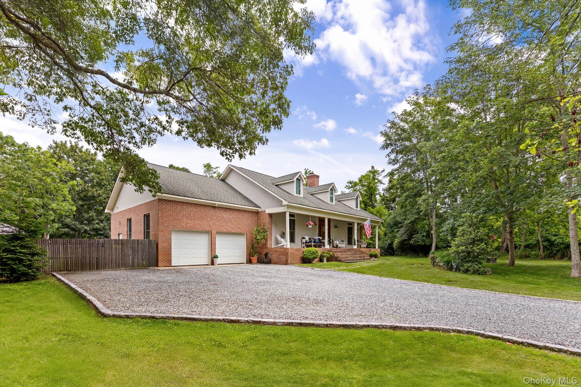 2 Sunset Road Sag Harbor, NY 11963 - Photo 3 of 21 Cape cod-style house featuring covered porch, brick siding, roof with shingles, driveway, and an attached garage