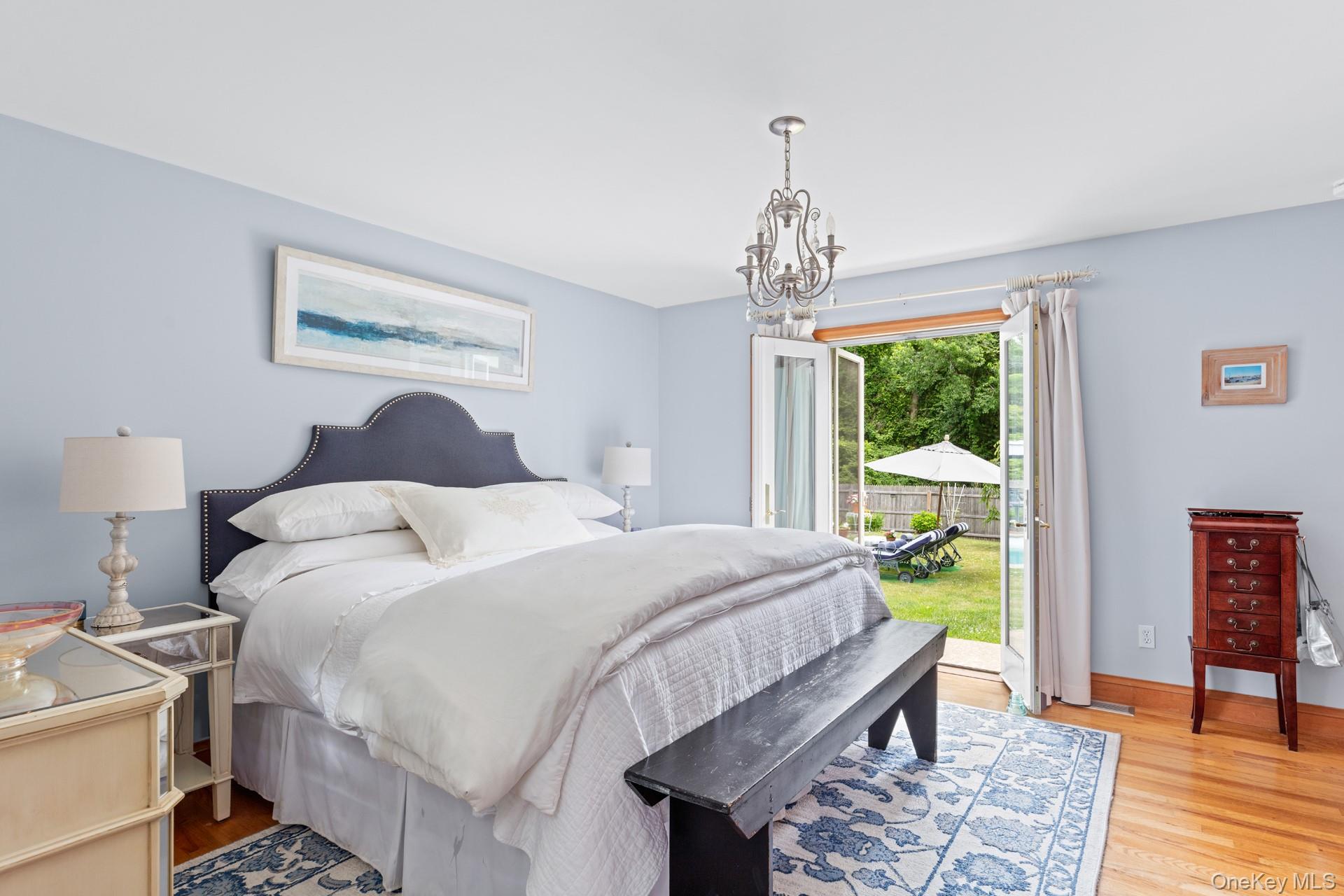 2 Sunset Road Sag Harbor, NY 11963 - Photo 8 of 21 a bedroom with a bed and a chandelier
