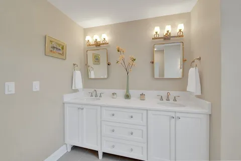 a bathroom with a double vanity sink and a mirror