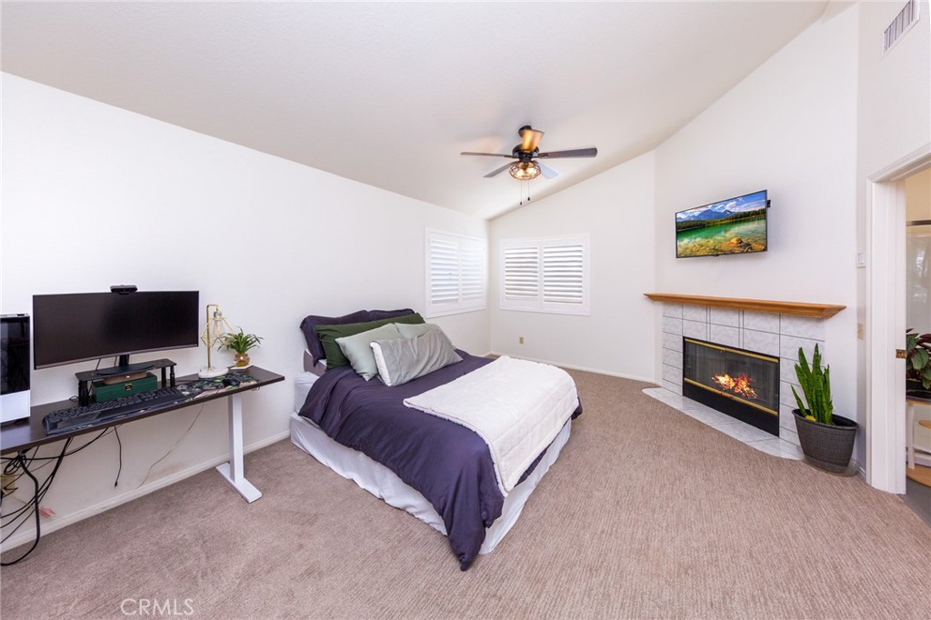 39752 Makin Avenue Palmdale, CA 93551 - Photo 8 of 15 a spacious bedroom with a bed and a fireplace
