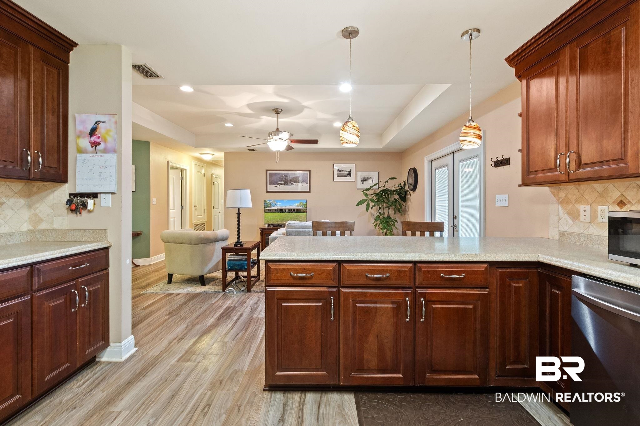 24250 Hack Road Bay Minette, AL 36507 - Photo 19 of 88 Kitchen featuring tasteful backsplash, stainless steel appliances, a peninsula, hanging light fixtures, and light wood-type flooring