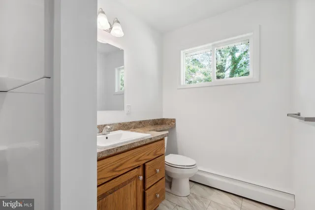 a bathroom with a toilet a sink and a window