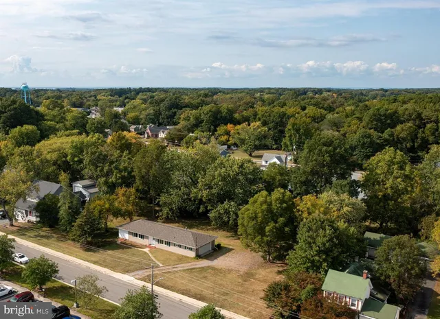 an aerial view of residential houses with outdoor space and trees