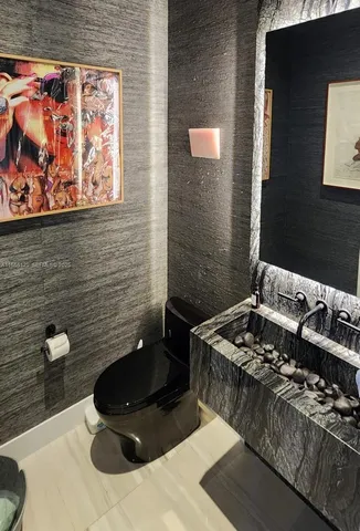 a bathroom with a sink and a stove with a toilet