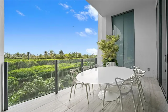 a view of a balcony with table and chairs and potted plants