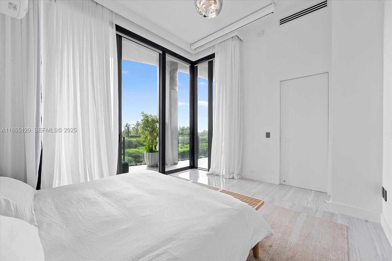 2811 South Bayshore Drive, Unit 4C Miami, FL 33133 - Photo 21 of 37 a bedroom with a bed and a large window