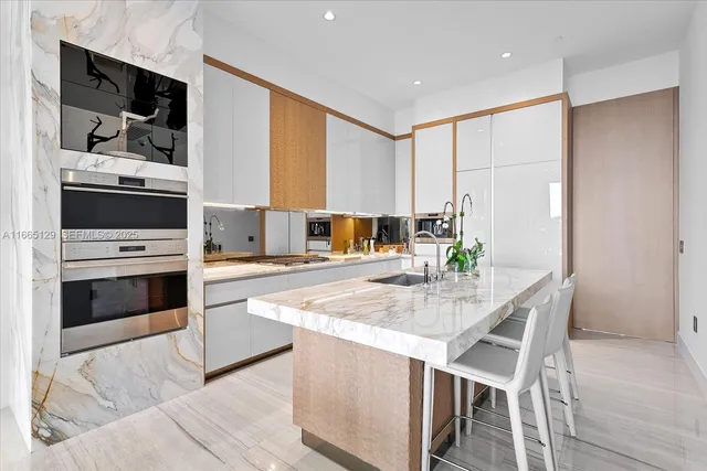 a kitchen with stainless steel appliances kitchen island granite countertop a stove a sink and a refrigerator