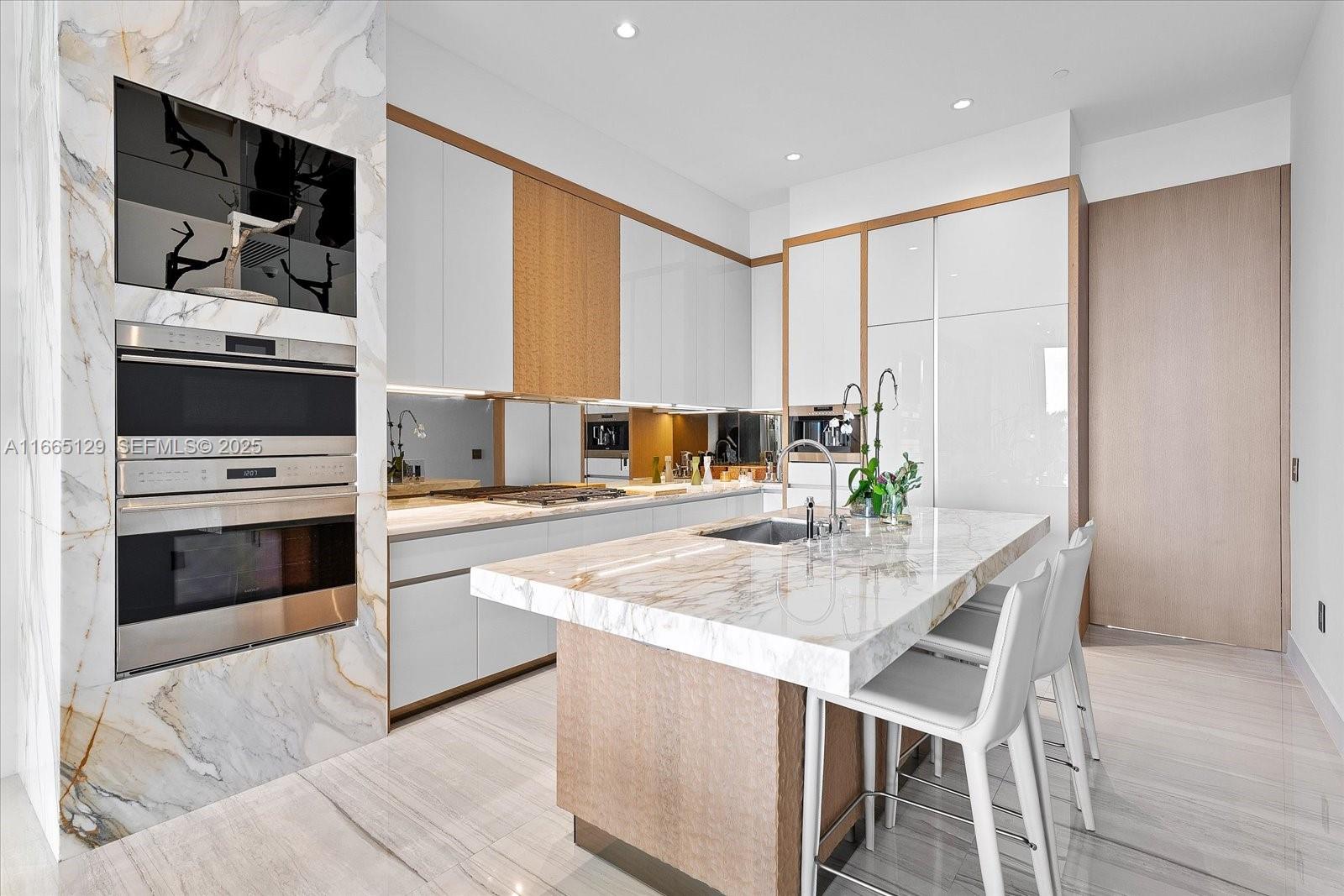2811 South Bayshore Drive, Unit 4C Miami, FL 33133 - Photo 9 of 37 a kitchen with stainless steel appliances kitchen island granite countertop a stove a sink and a refrigerator