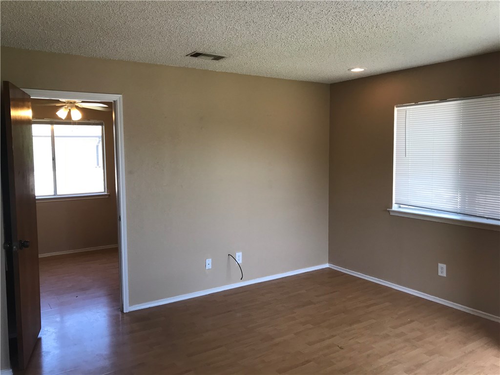 1638 Post Road, Unit B San Marcos, TX 78666 - Photo 4 of 6 an empty room with wooden floor and windows