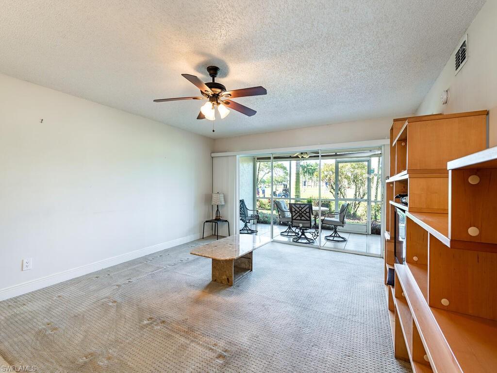 5920 Cranbrook Way, Unit F106 Naples, FL 34112 - Photo 3 of 12 a living room with furniture and white walls