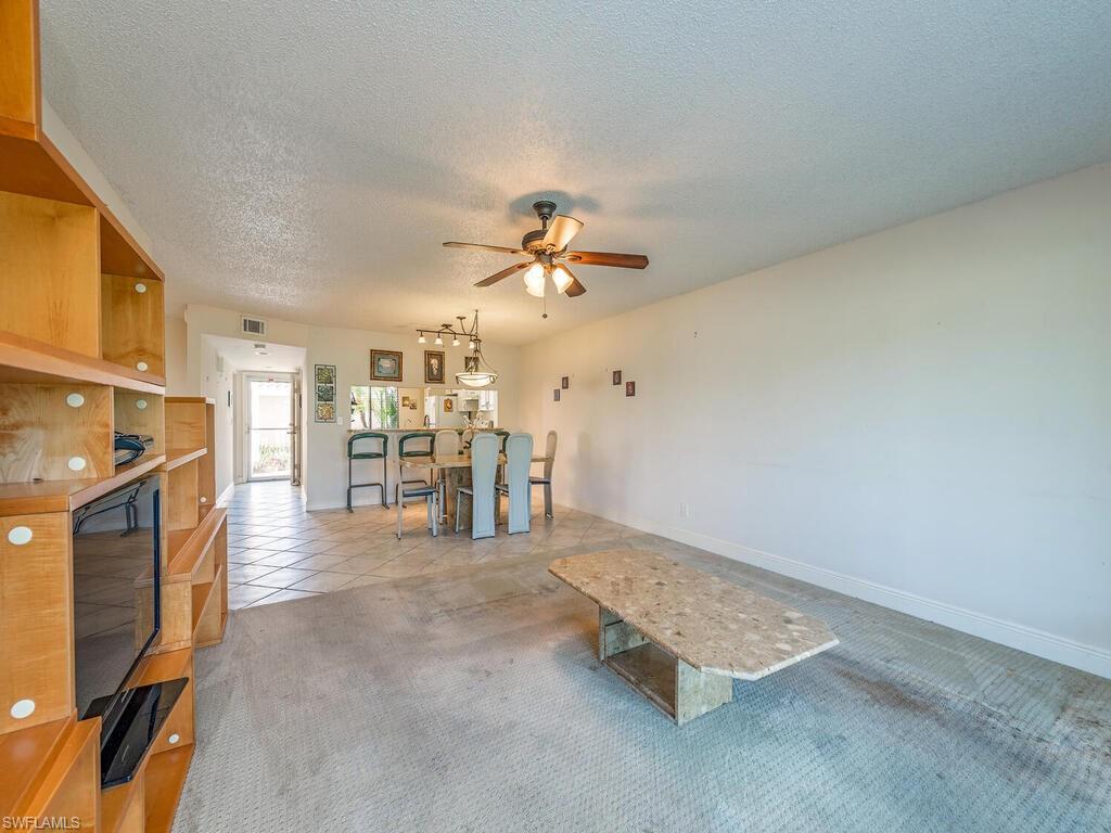 5920 Cranbrook Way, Unit F106 Naples, FL 34112 - Photo 4 of 12 a view of a livingroom with furniture and a ceiling fan