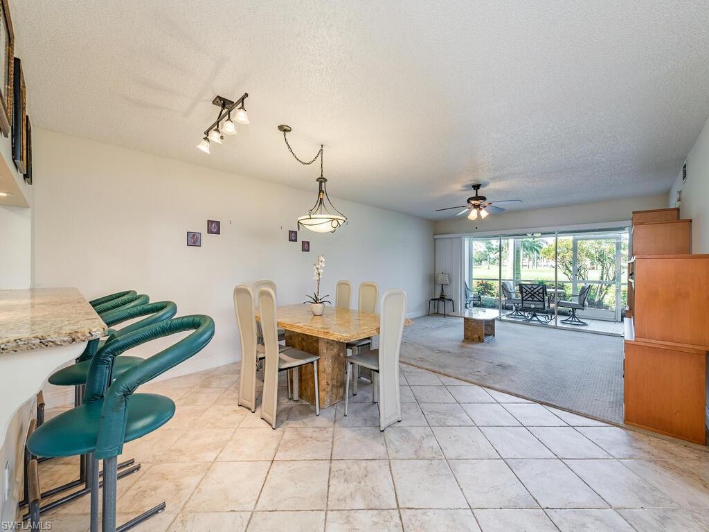 5920 Cranbrook Way, Unit F106 Naples, FL 34112 - Photo 5 of 12 a view of a dining room with furniture and chandelier