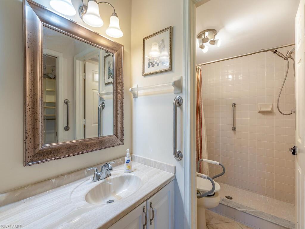 5920 Cranbrook Way, Unit F106 Naples, FL 34112 - Photo 8 of 12 a bathroom with a sink a toilet and shower