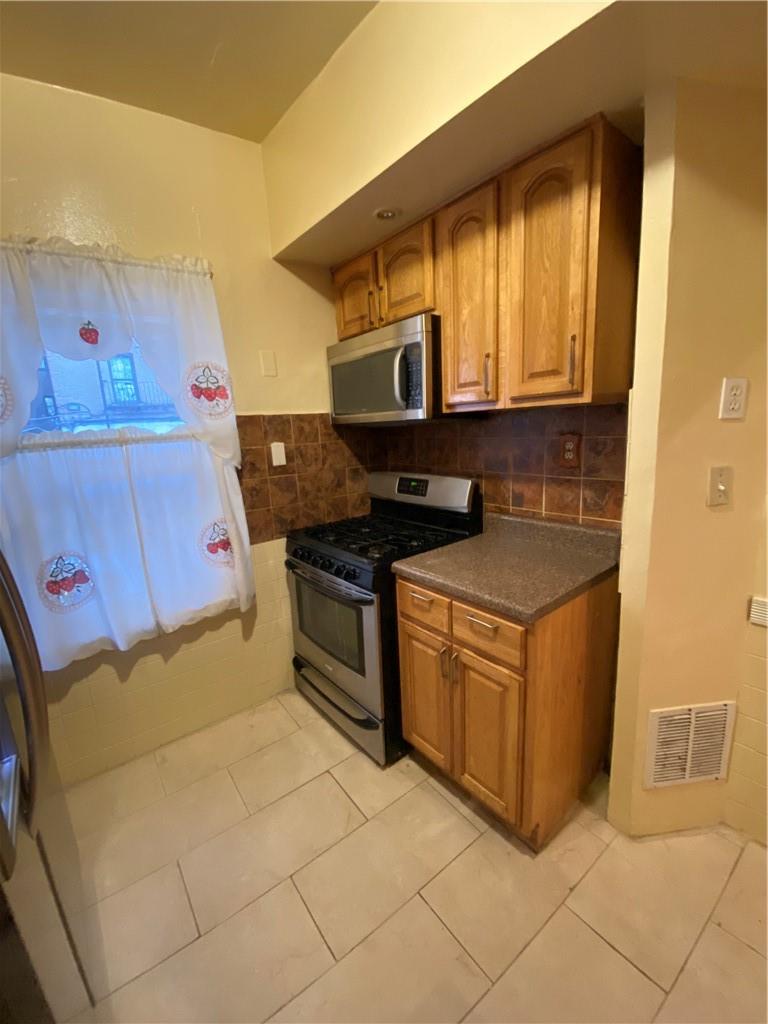 4058 Bronx Boulevard Bronx, NY 10466 - Photo 5 of 19 a kitchen with stainless steel appliances granite countertop a stove a sink and a microwave