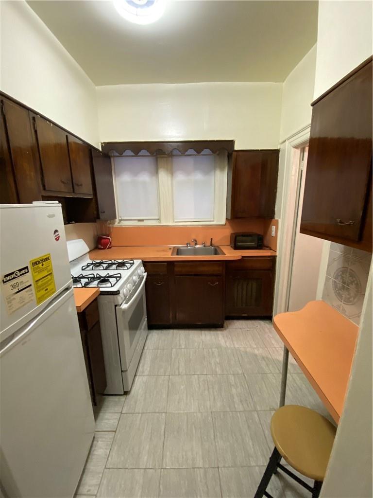 4058 Bronx Boulevard Bronx, NY 10466 - Photo 10 of 19 a kitchen with stainless steel appliances a stove a sink and a refrigerator