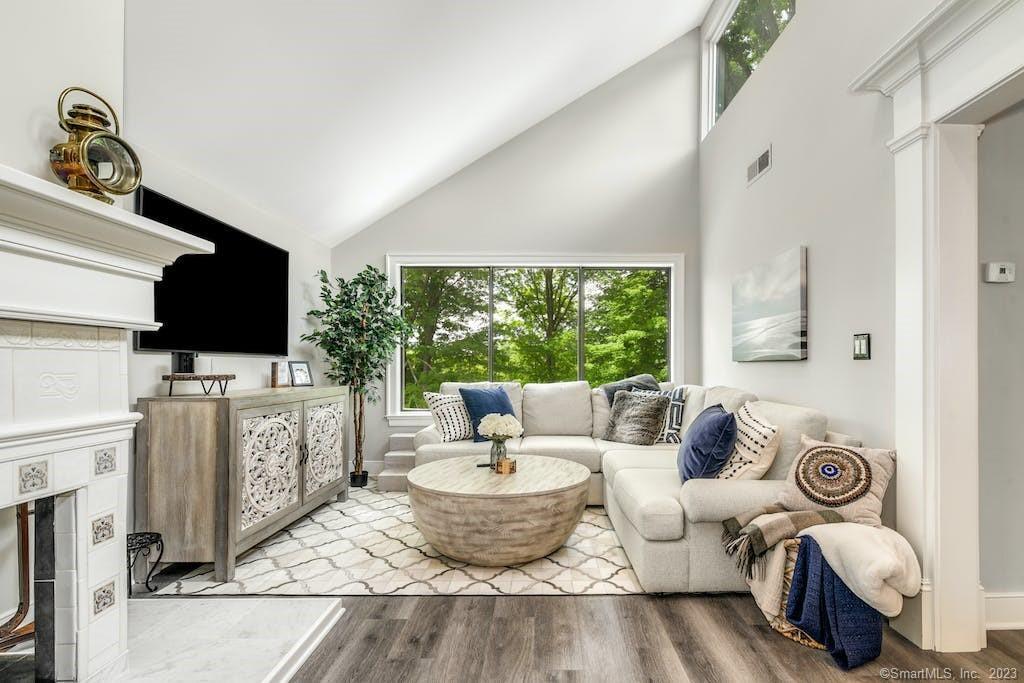 8 Sugar Maple Lane, Unit 8 Ridgefield, CT 06877 - Photo 1 of 1 a living room with furniture a flat screen tv and a floor to ceiling window