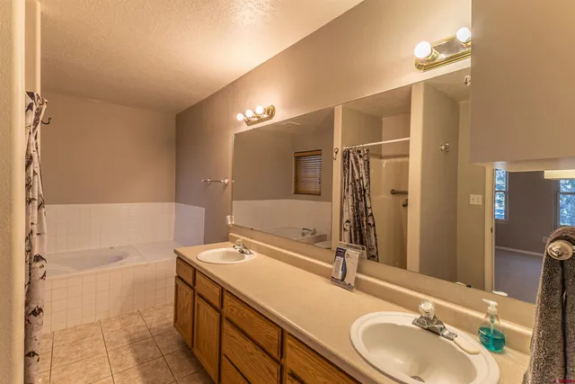 a bathroom with a sink a toilet a mirror and shower