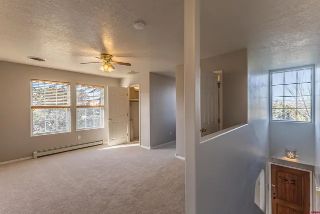 a view of an empty room with a chandelier fan