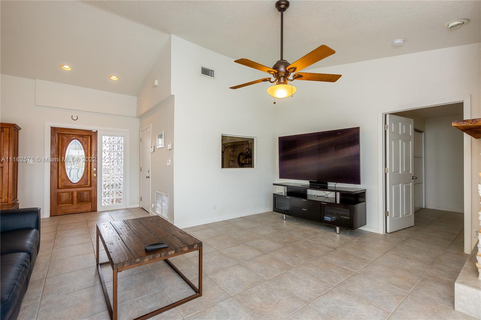 11612 Quiet Waters Lane Boca Raton, FL 33428 - Photo 11 of 70 a living room with furniture and a flat screen tv