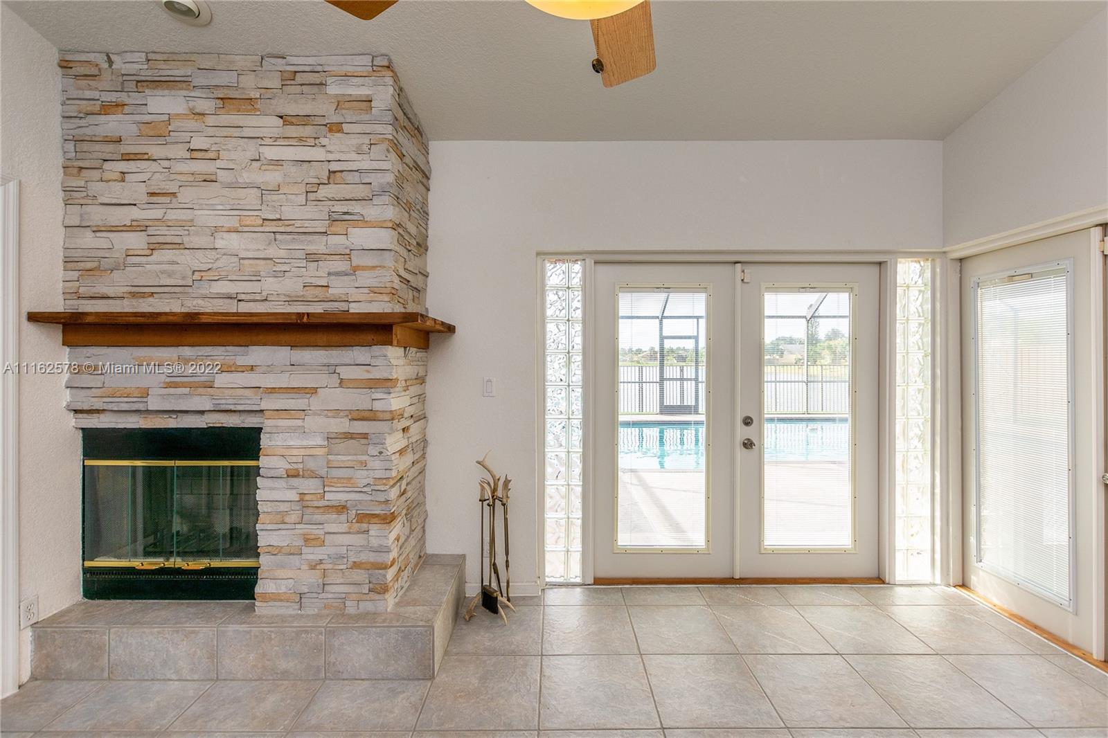 11612 Quiet Waters Lane Boca Raton, FL 33428 - Photo 17 of 70 a view of an empty room with a fireplace and a window