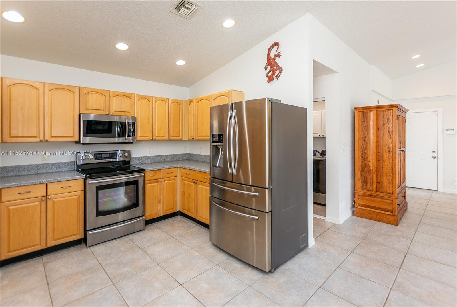 11612 Quiet Waters Lane Boca Raton, FL 33428 - Photo 29 of 70 a kitchen with granite countertop a refrigerator and a stove top oven