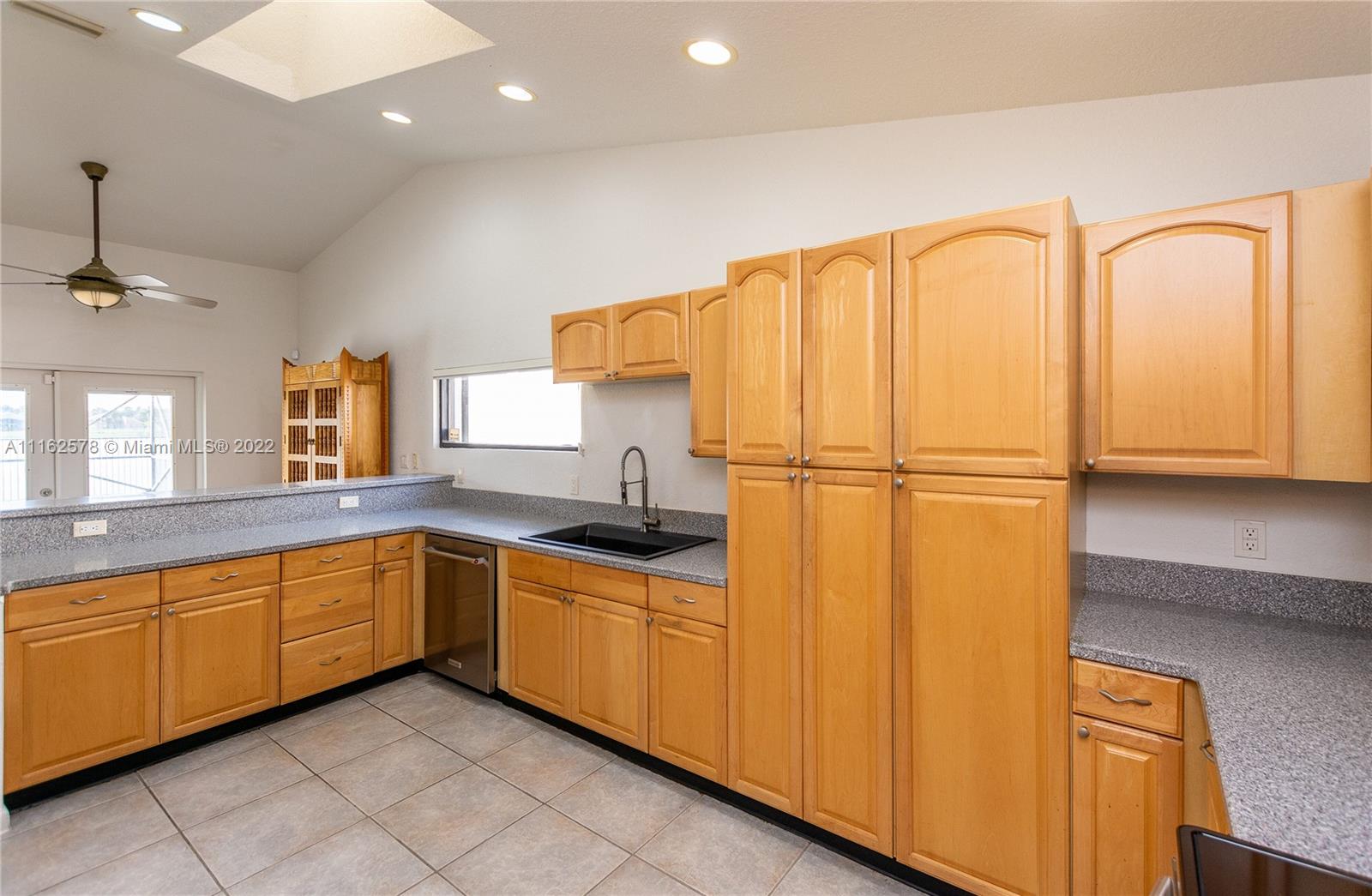 11612 Quiet Waters Lane Boca Raton, FL 33428 - Photo 31 of 70 a kitchen with stainless steel appliances granite countertop a sink and a refrigerator