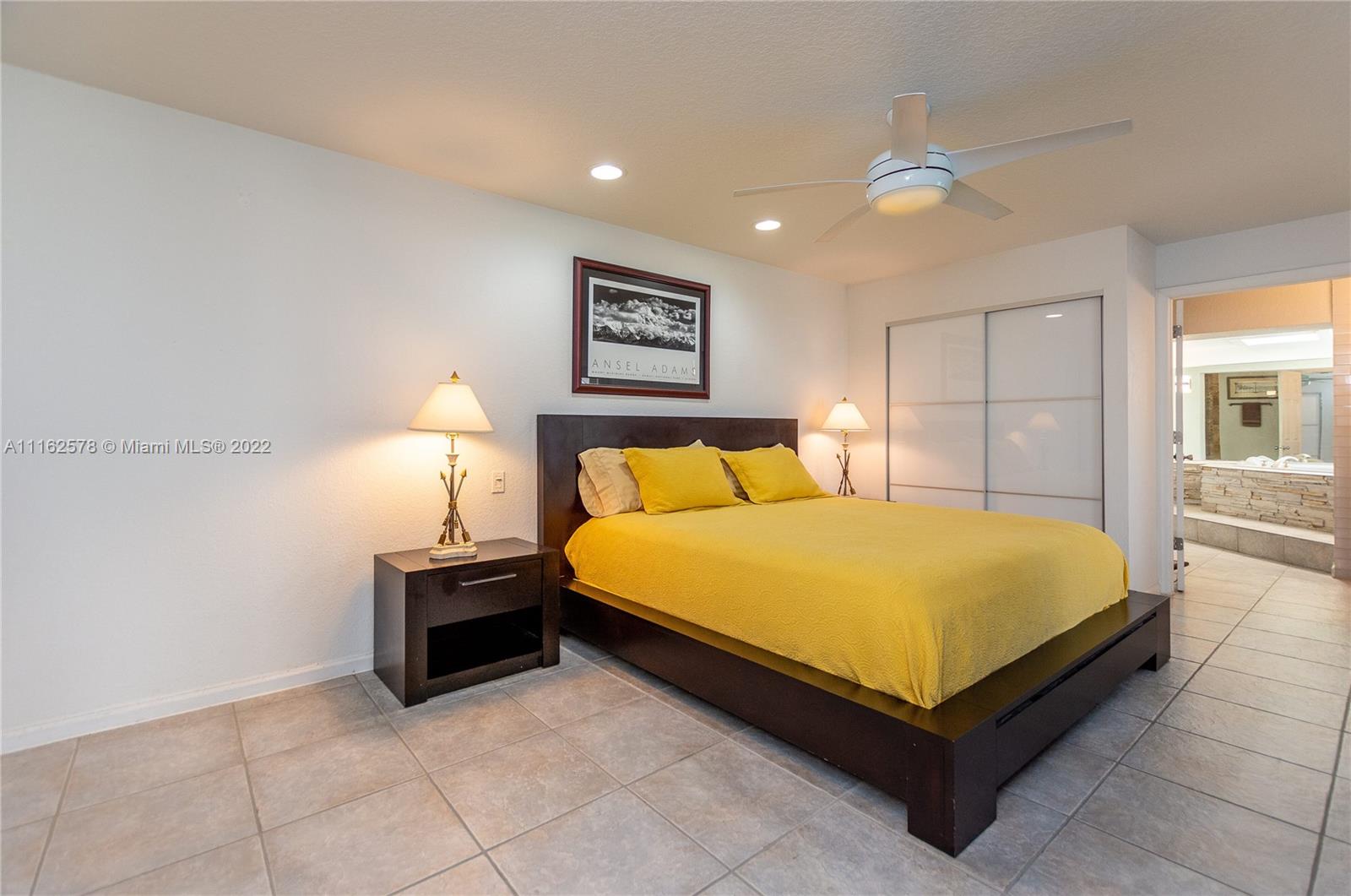 11612 Quiet Waters Lane Boca Raton, FL 33428 - Photo 33 of 70 a spacious bedroom with a bed and a lamp on table