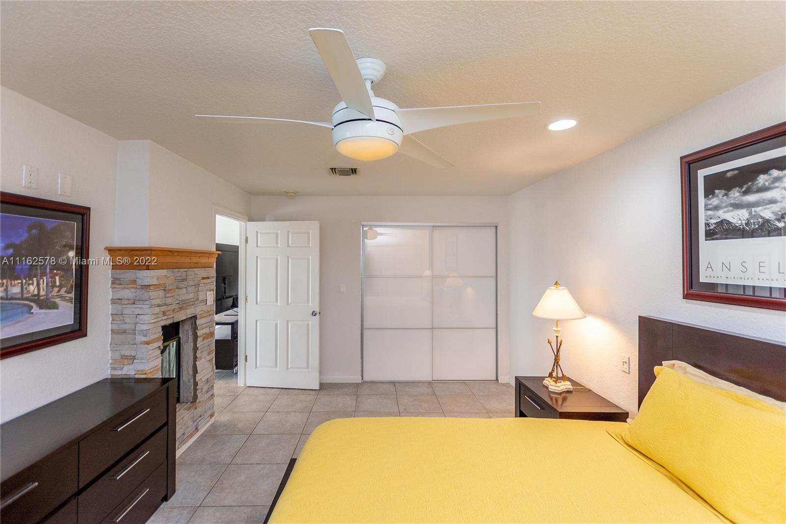 11612 Quiet Waters Lane Boca Raton, FL 33428 - Photo 35 of 70 a spacious bedroom with a bed and a chandelier