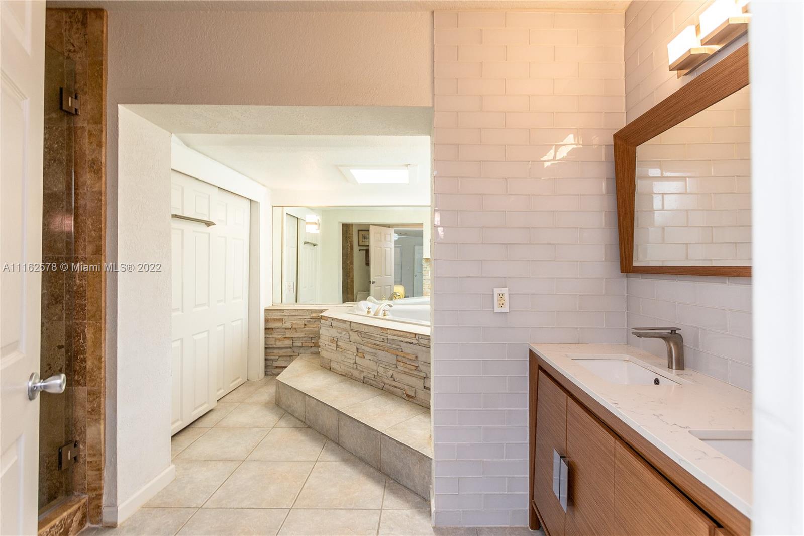 11612 Quiet Waters Lane Boca Raton, FL 33428 - Photo 38 of 70 a bathroom with a tub sink and mirror