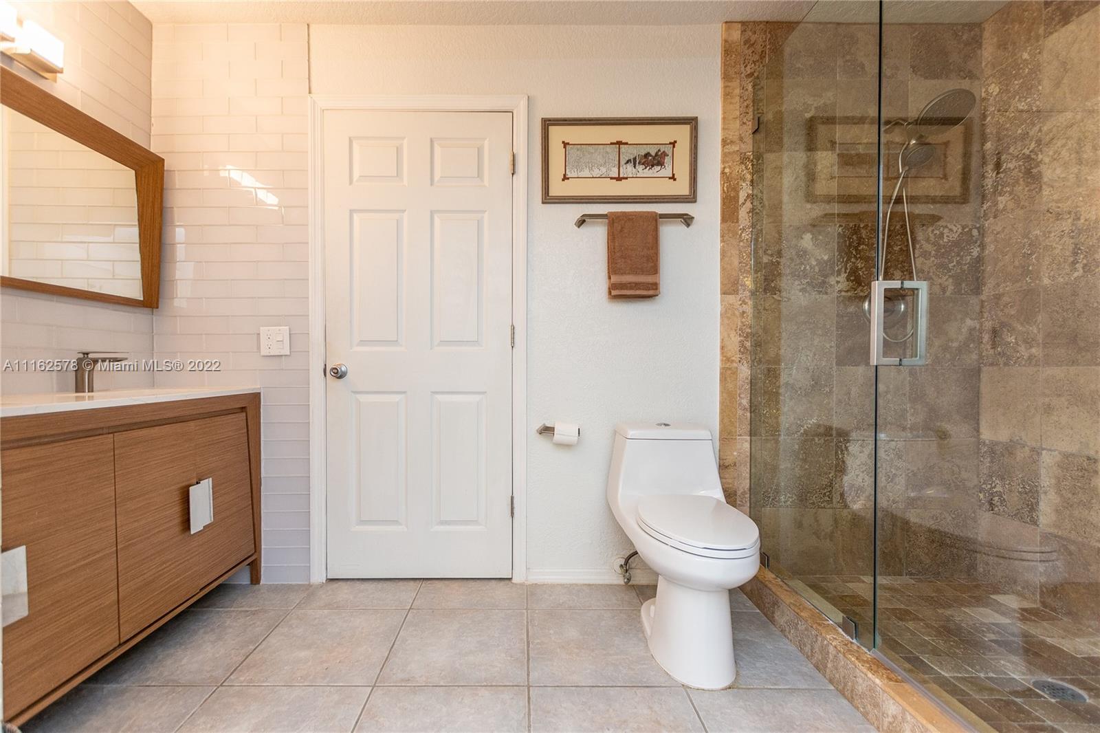 11612 Quiet Waters Lane Boca Raton, FL 33428 - Photo 39 of 70 a bathroom with a toilet sink and shower