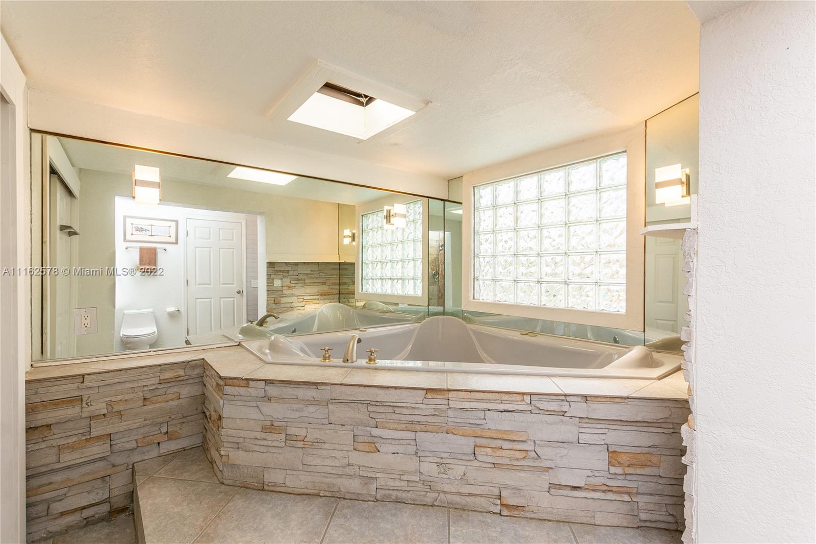 11612 Quiet Waters Lane Boca Raton, FL 33428 - Photo 40 of 70 a bathroom with bathtub and window