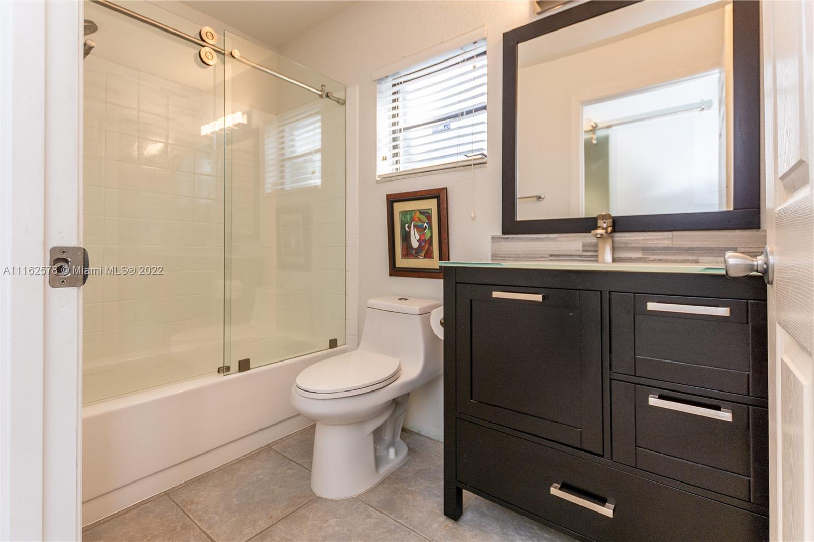 11612 Quiet Waters Lane Boca Raton, FL 33428 - Photo 45 of 70 a bathroom with a double vanity sink toilet and shower