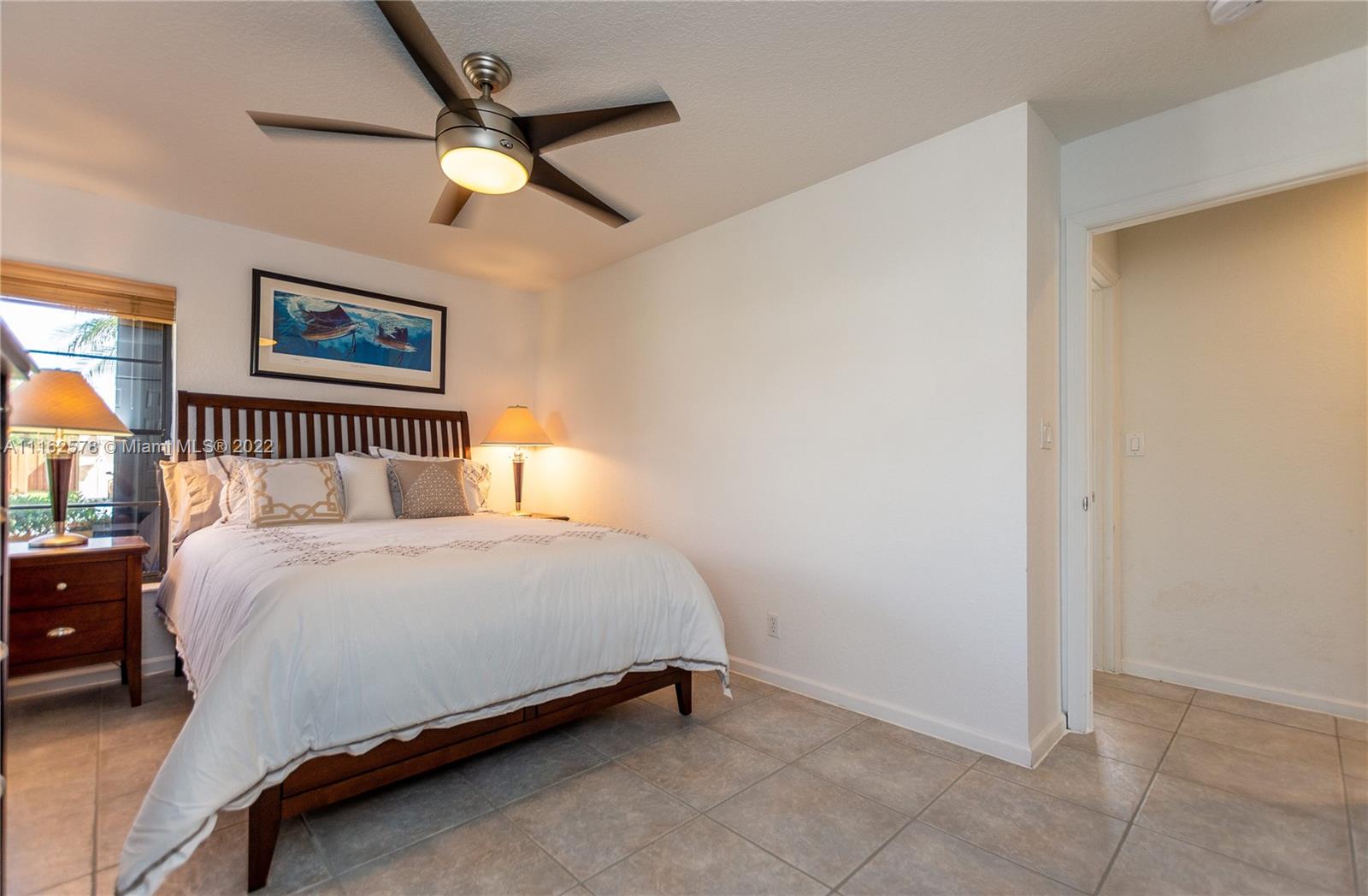 11612 Quiet Waters Lane Boca Raton, FL 33428 - Photo 47 of 70 a bedroom with a bed and a ceiling fan