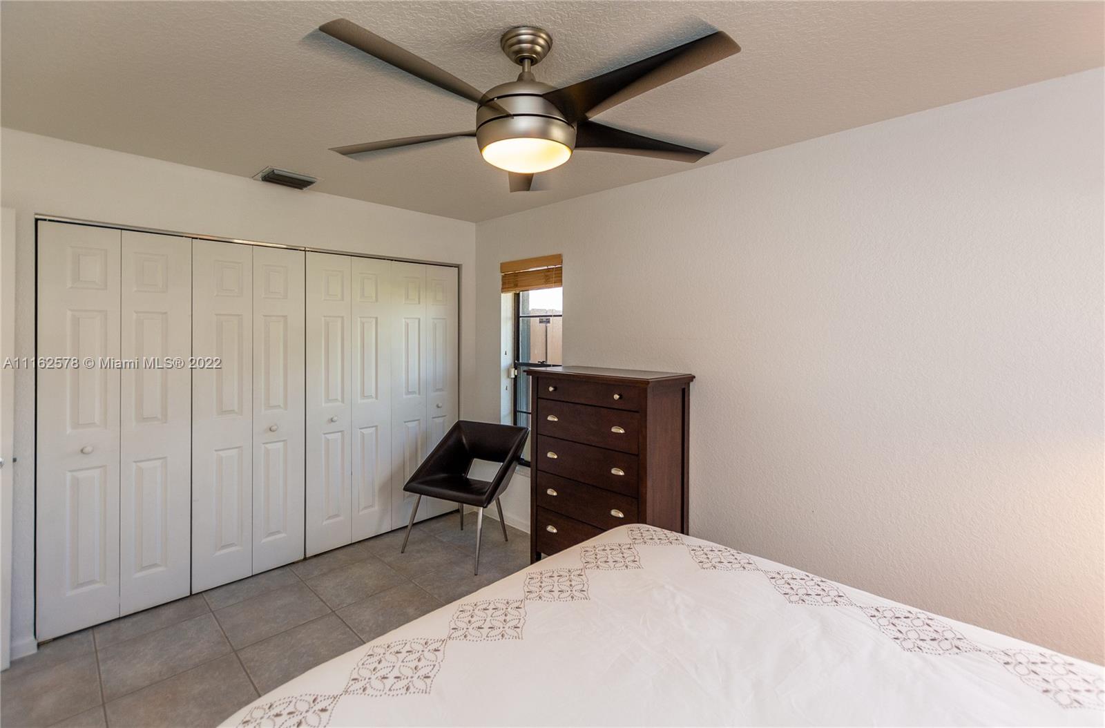 11612 Quiet Waters Lane Boca Raton, FL 33428 - Photo 48 of 70 a bedroom with a bed and a chandelier