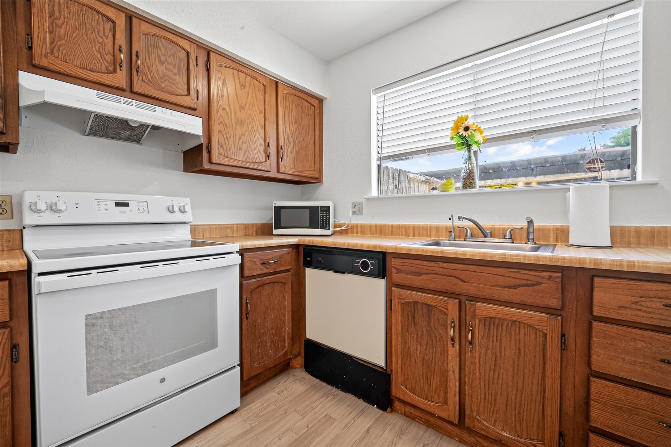 6401 Deihl Road, Unit 902 Houston, TX 77092 - Photo 10 of 35 Charming kitchen featuring warm wooden cabinets, appliances, and a sunlit window perfect for enjoying morning views.