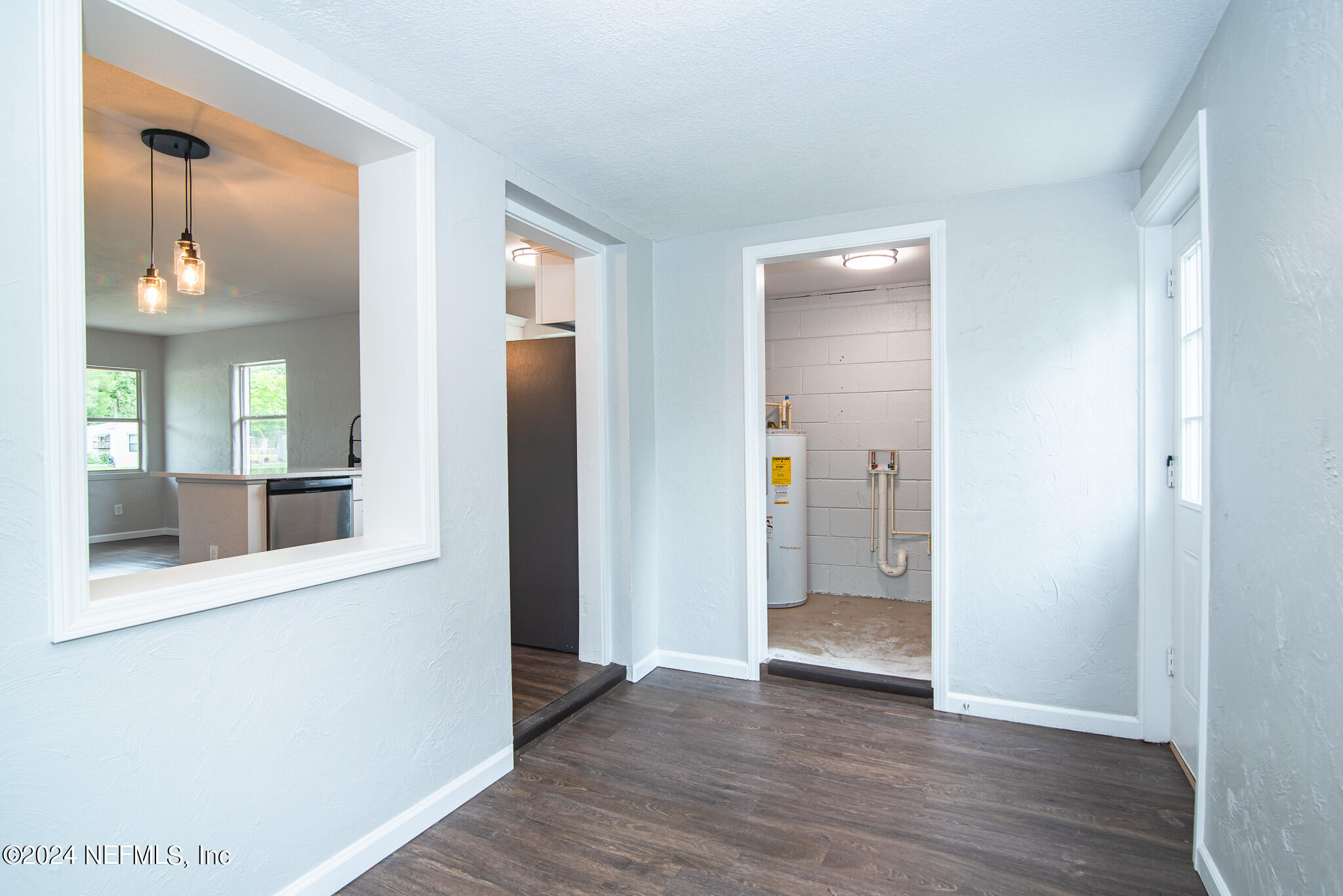 1702 King Arthur Road Jacksonville, FL 32211 - Photo 13 of 24 a view of an empty room with wooden floor and a mirror