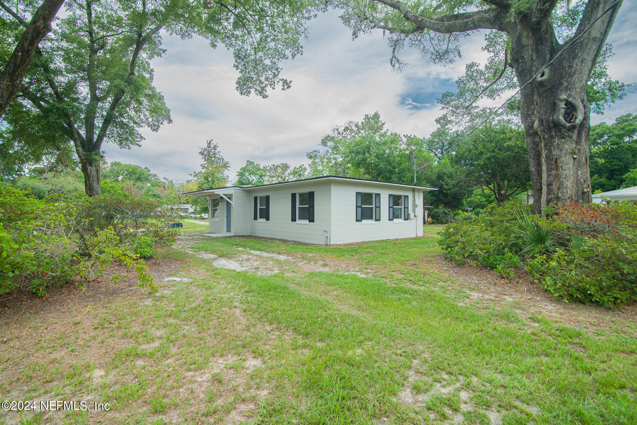 1702 King Arthur Road Jacksonville, FL 32211 - Photo 24 of 24 a backyard of a house with plants and large tree