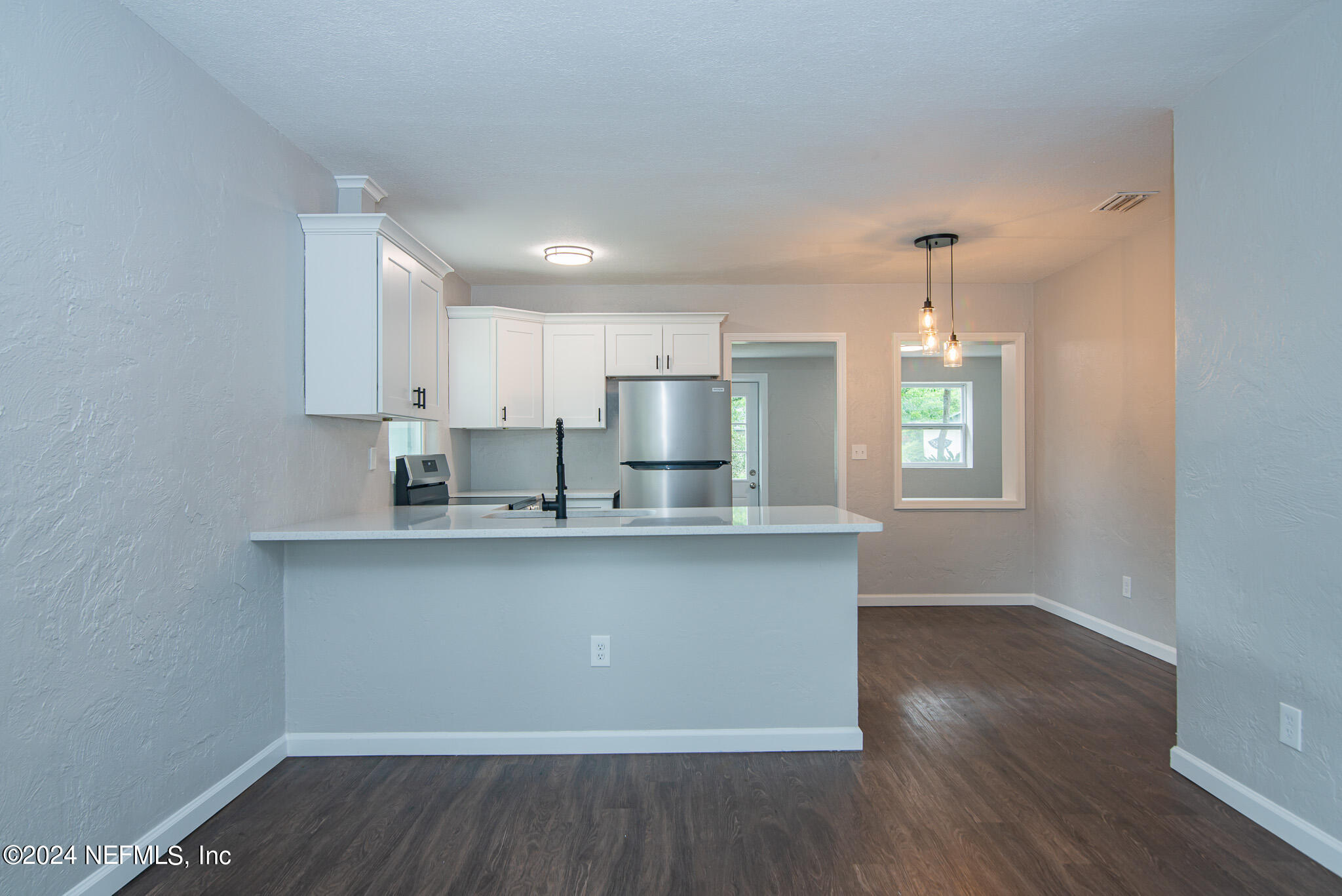 1702 King Arthur Road Jacksonville, FL 32211 - Photo 6 of 24 a kitchen with stainless steel appliances granite countertop a sink a stove a refrigerator cabinets and wooden floor