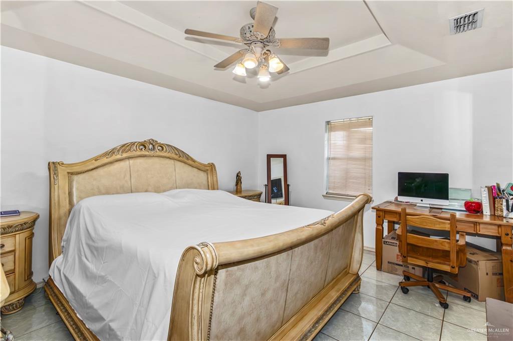 2509 Coma Street Hidalgo, TX 78557 - Photo 8 of 12 a bedroom with a bed and a chandelier