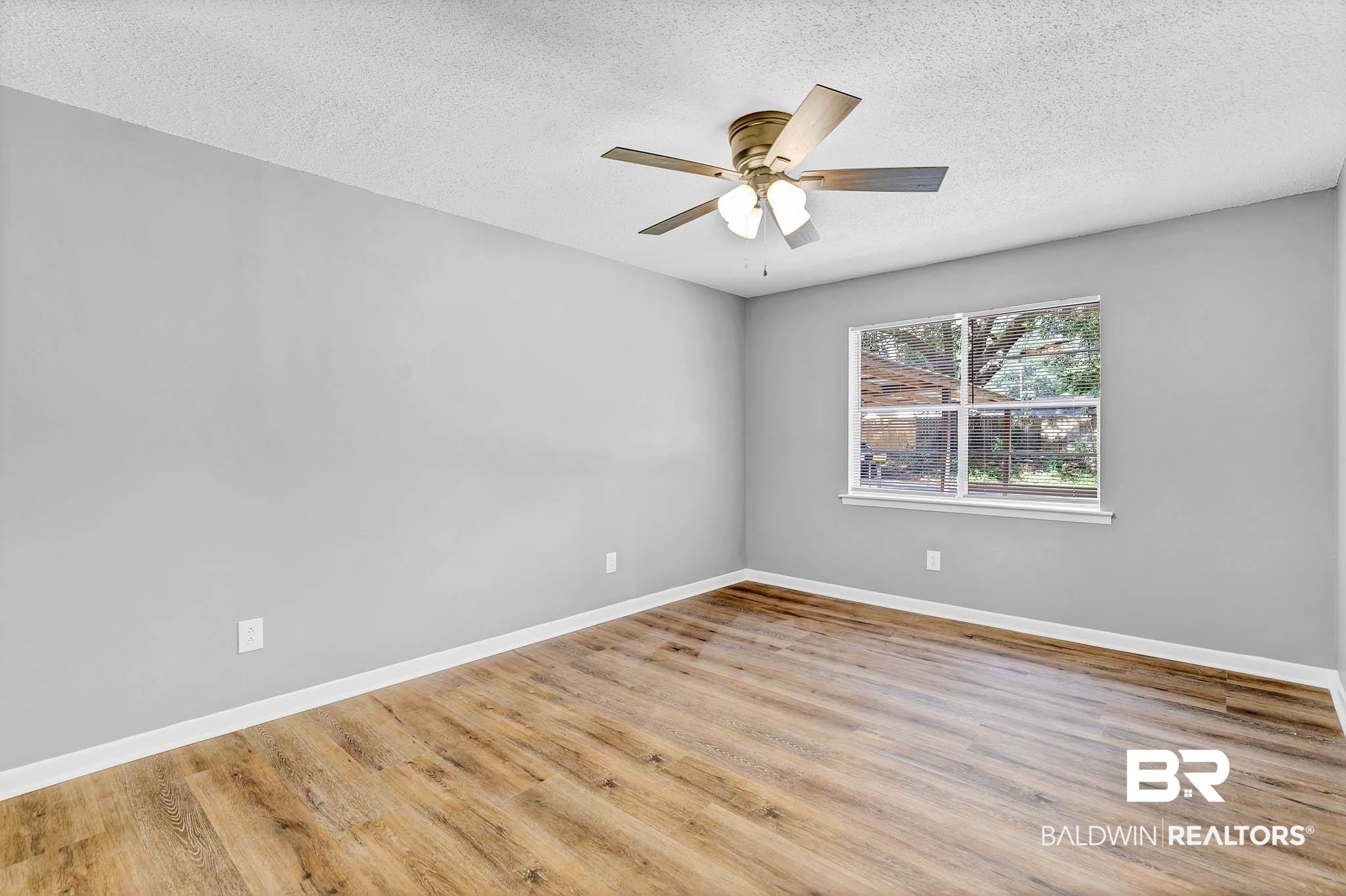 3304 Armond Drive Mobile, AL 36605 - Photo 7 of 62 Empty room featuring a textured ceiling, wood finished floors, and ceiling fan