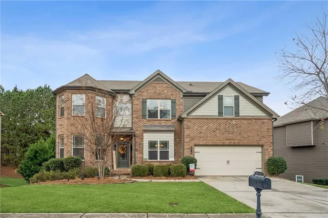 a front view of a house with a yard and trees