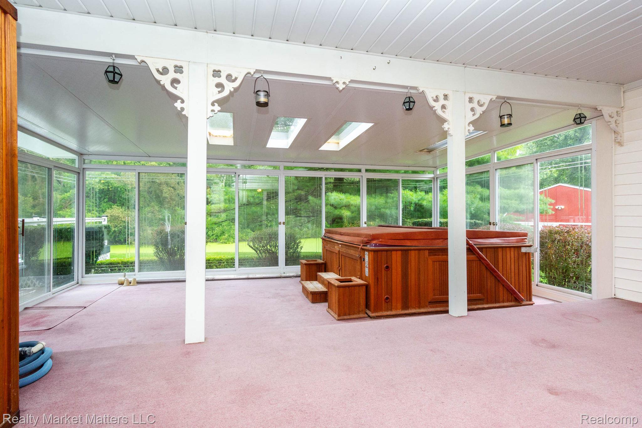 770 North Fairgrounds Road Imlay City, MI 48444 - Photo 11 of 55 Enclosed sunroom featuring a built-in spa, skylights, and extensive glass paneling