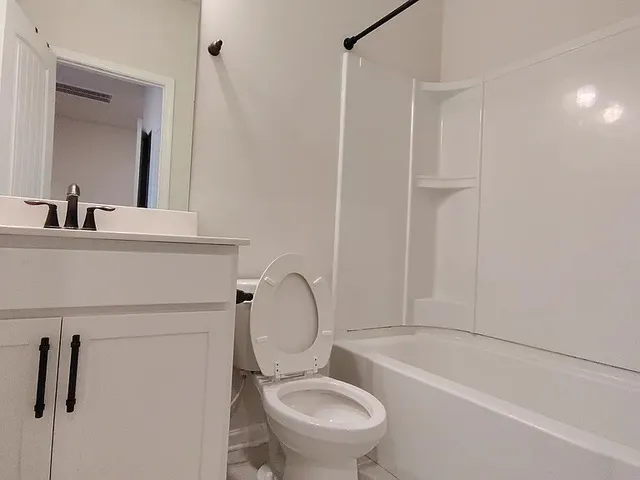 a white toilet sitting next to a bathroom sink