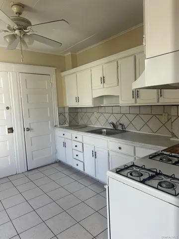 a kitchen with granite countertop a sink stove and cabinets