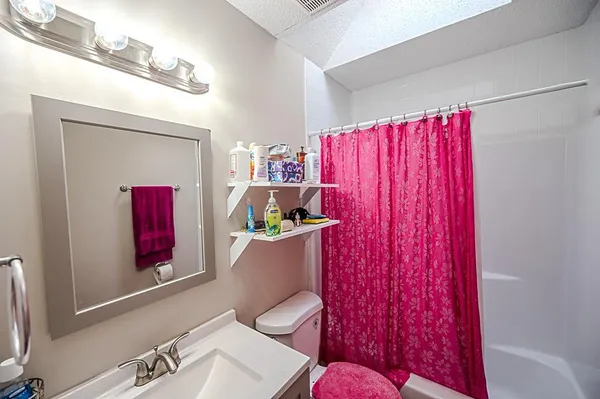 a bathroom with a toilet and a shower curtain