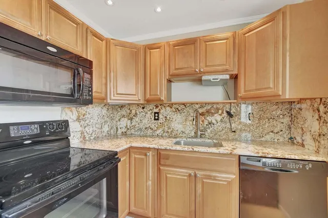 a kitchen with stainless steel appliances granite countertop a sink stove and microwave