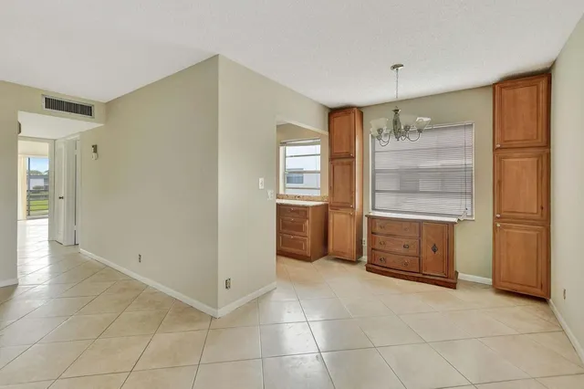 a view of a kitchen with an empty space and wooden shelves